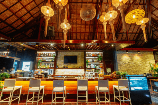 Bar counter with woven pendant lights and stools