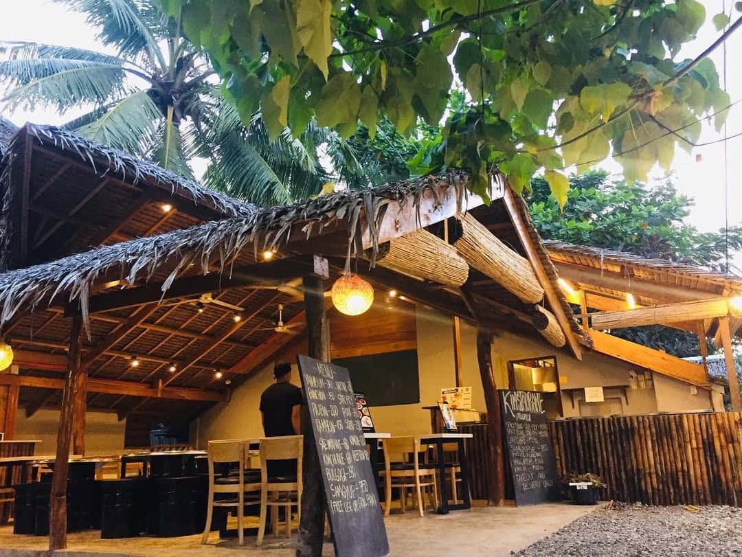 Open sided restaurant with a thatched roof among palms