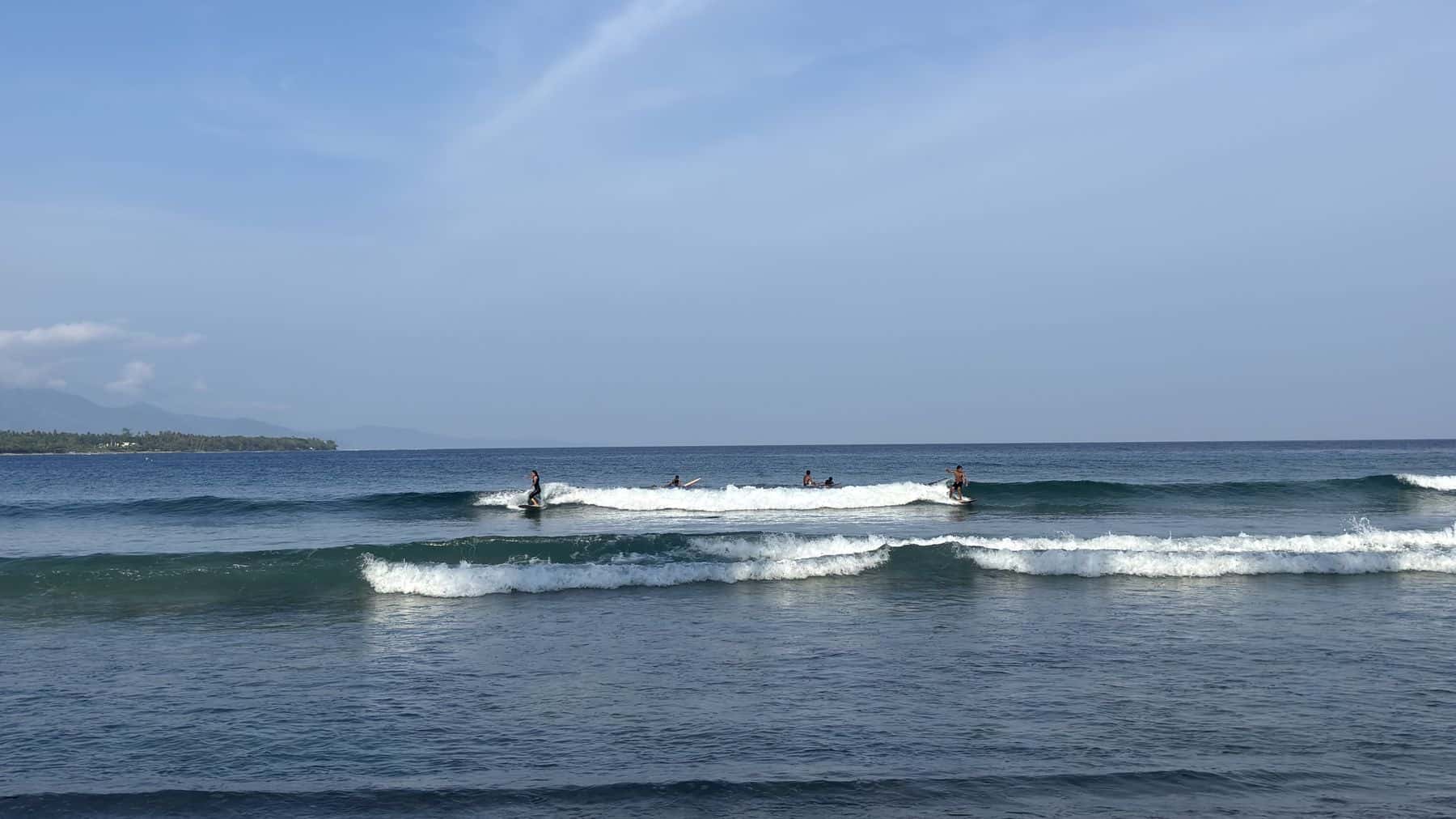 Surfers riding a small peak at Suyop