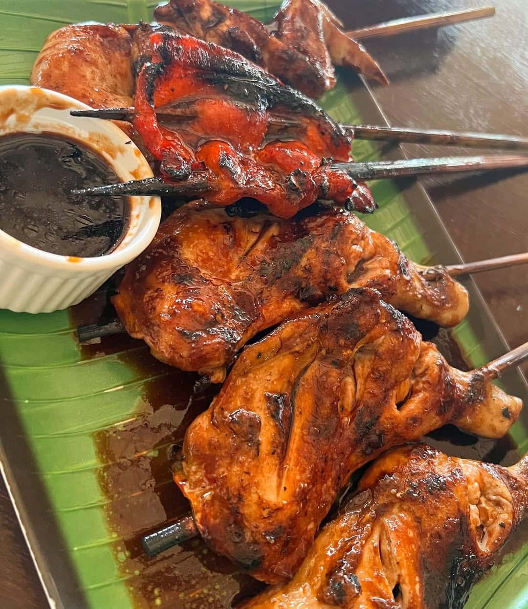 Charred barbecue chicken served on banana leaf