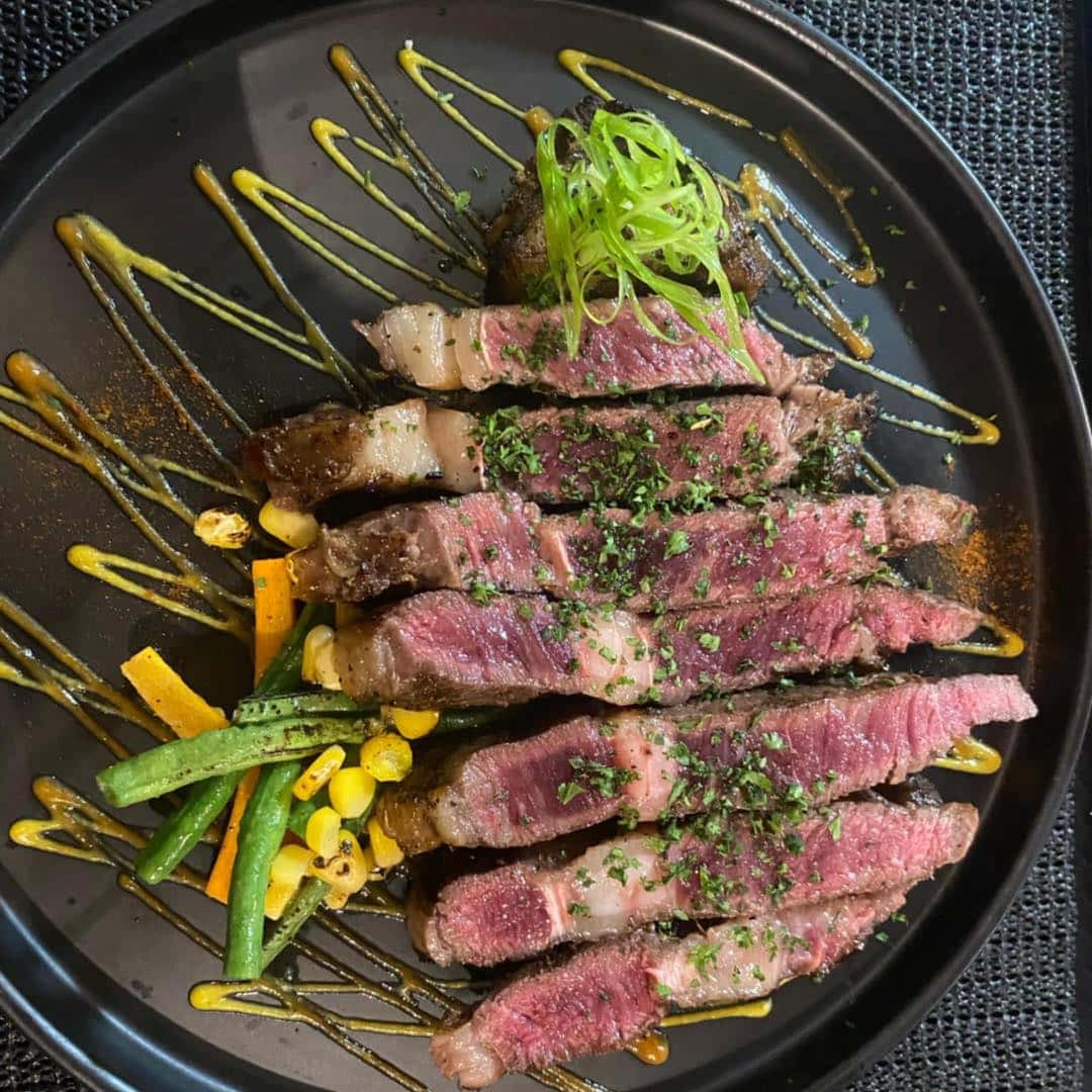 Sliced steak served on a board with wine
