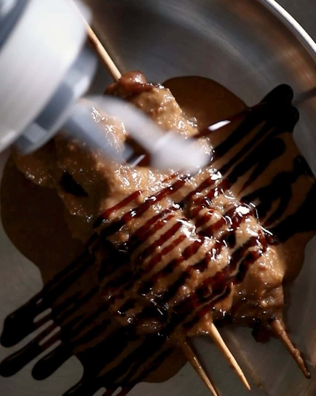 Chicken satay drizzled with peanut sauce