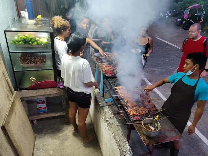 Street barbecue stall with smoke rising from the grill