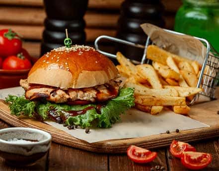 Chicken burger and fries on a wooden board