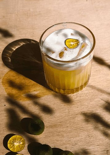 Cloudy citrus drink in a glass on a wooden table