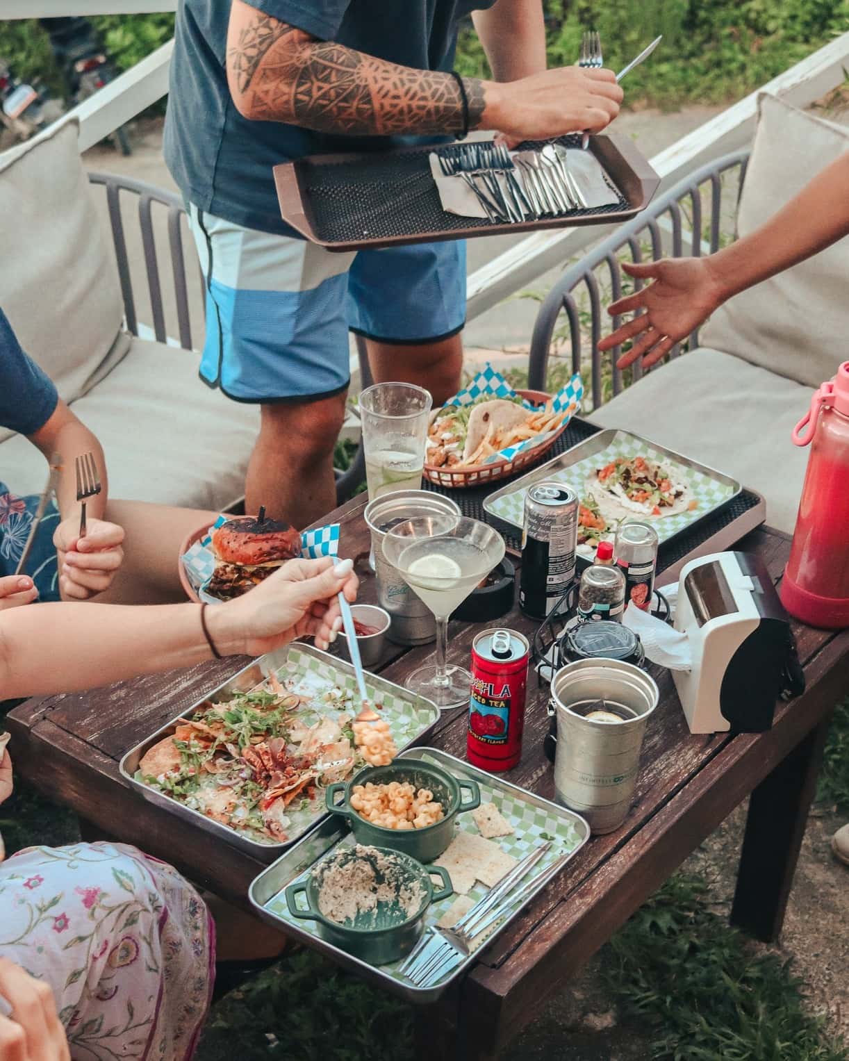 Friends sharing nachos and drinks around a low table