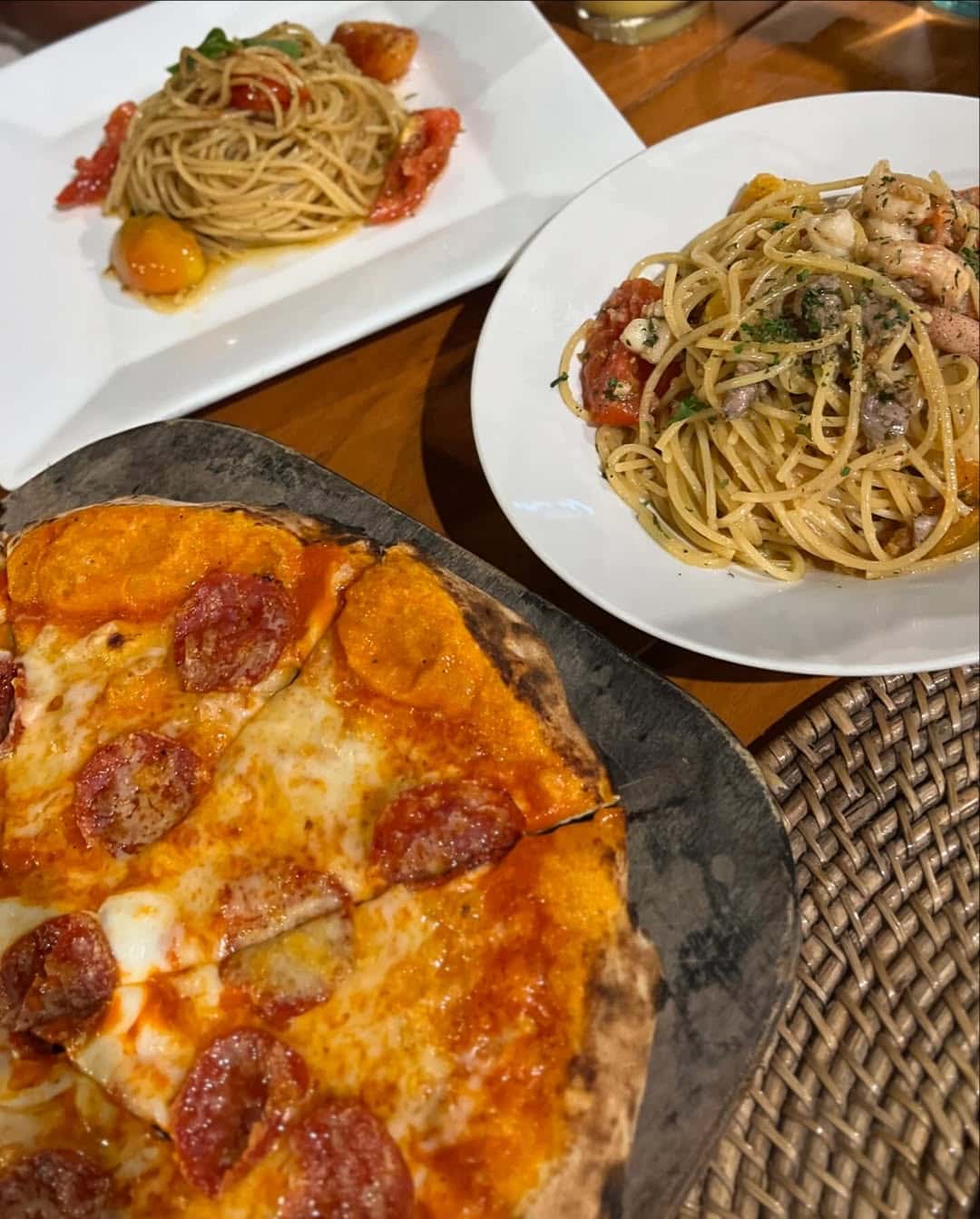 Pepperoni pizza beside a bowl of spaghetti