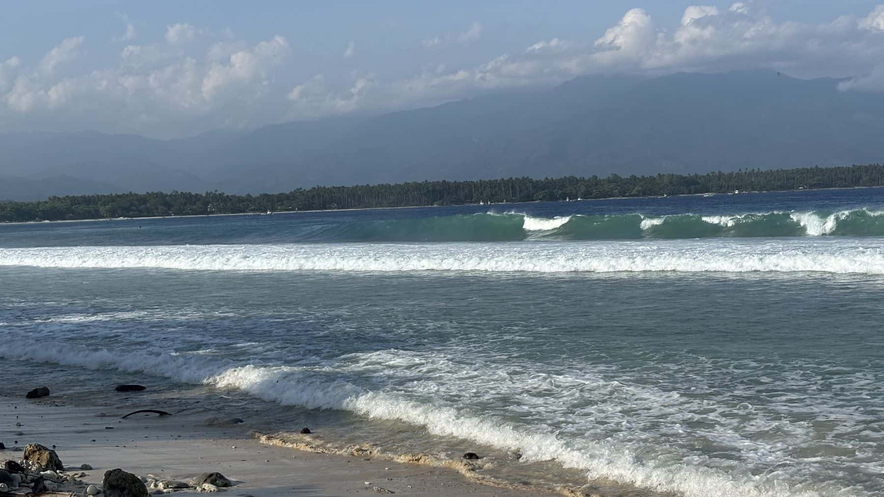 Waves running in at Kong and Bin with rocks on the sand in the foreground