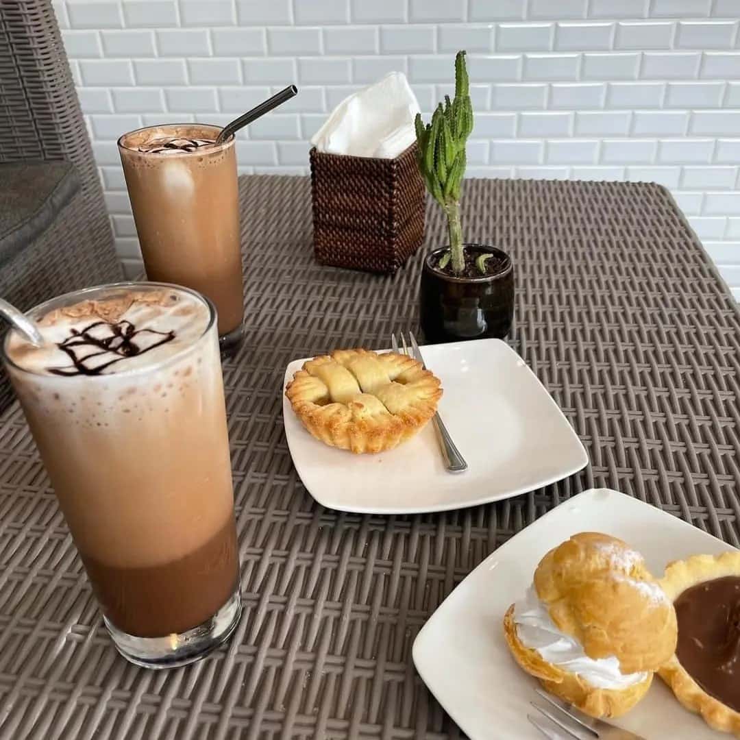 Iced coffees and a slice of banana cake on a table