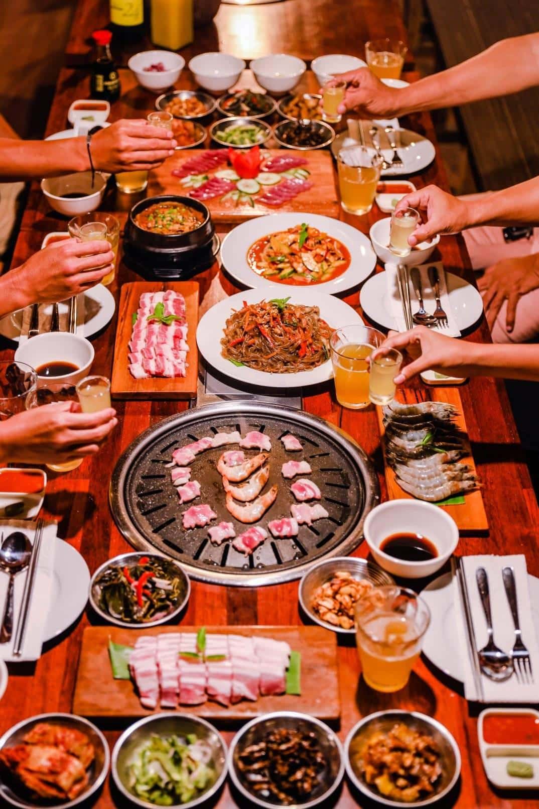 Korean barbecue grill with pork belly and shared side dishes