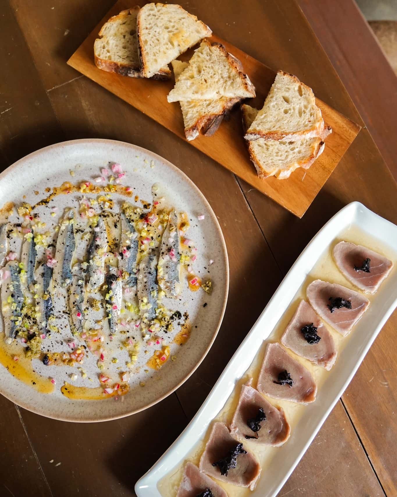 Marinated anchovies plated with herbs and spices