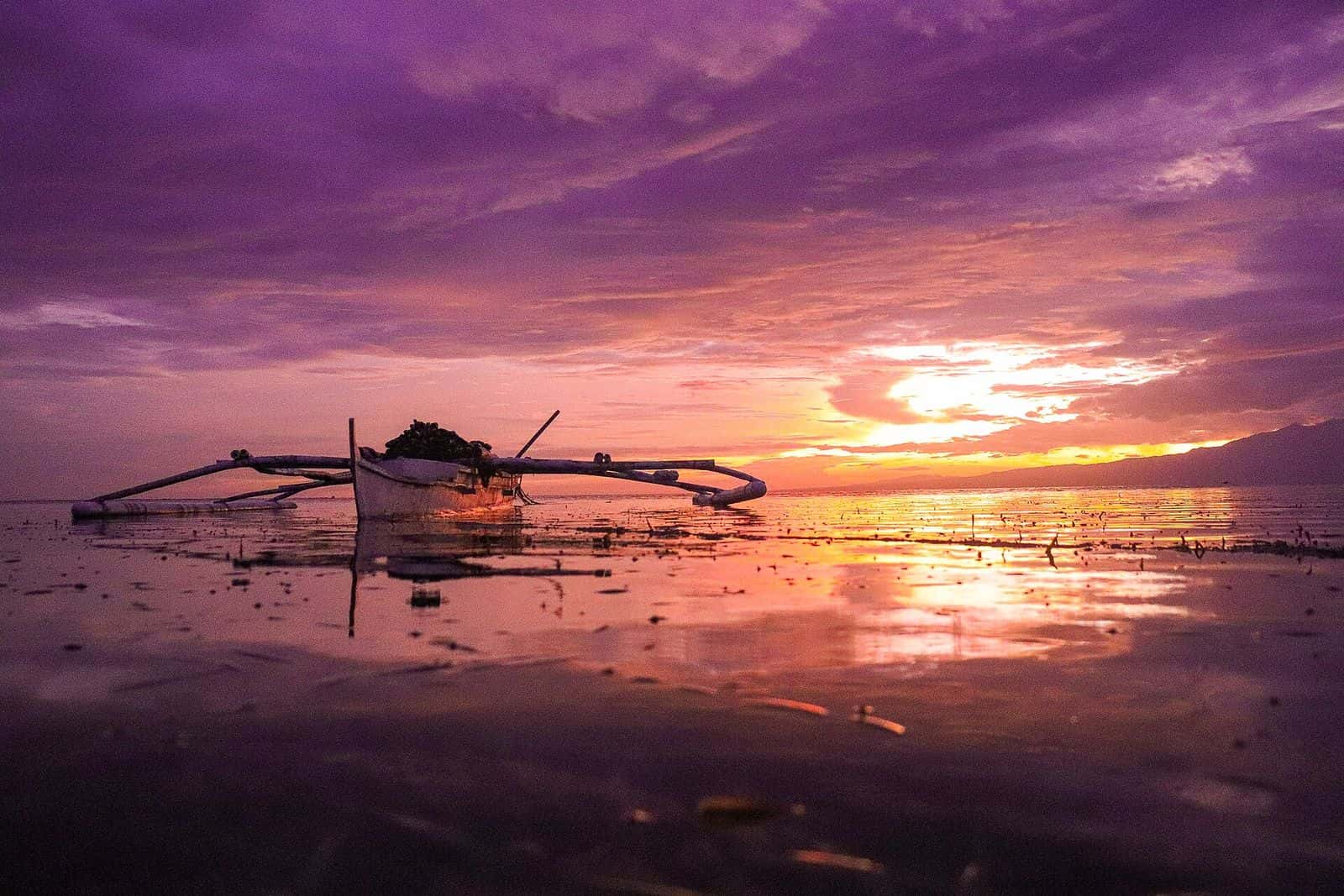 Outrigger boat at sunset off Tubod, San Juan, Siquijor