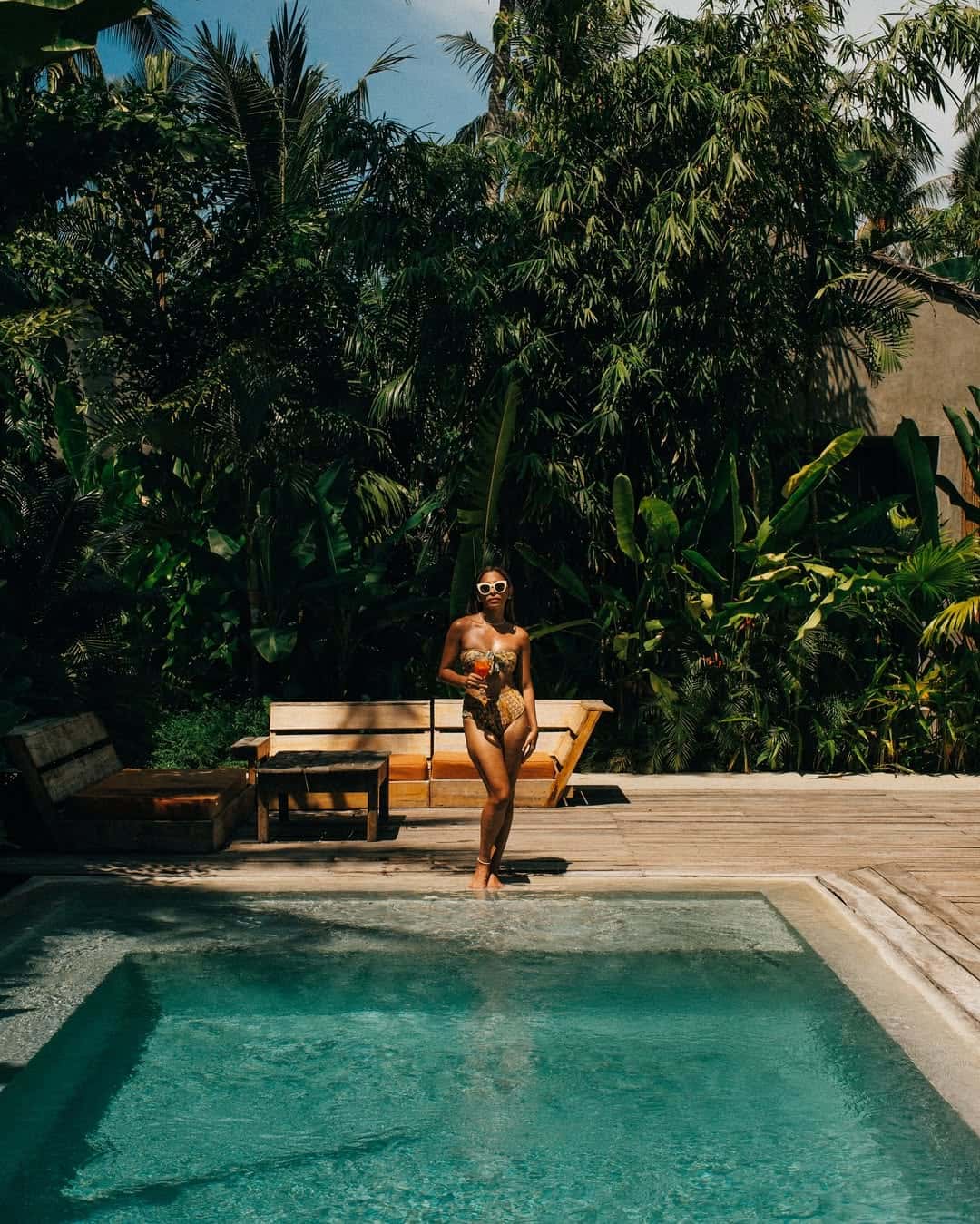 Sun lounger beside the jungle-fringed pool