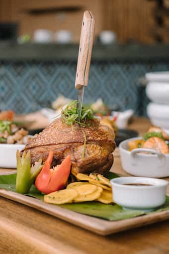 Roast chicken being basted at the table