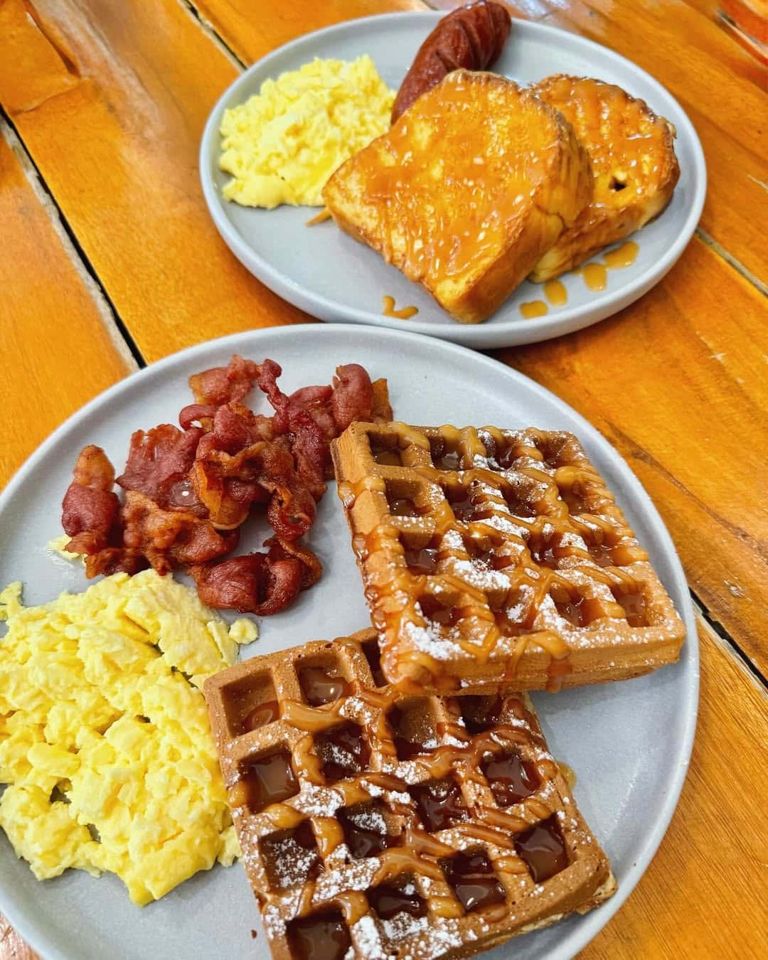 Breakfast plate of waffles, bacon and eggs