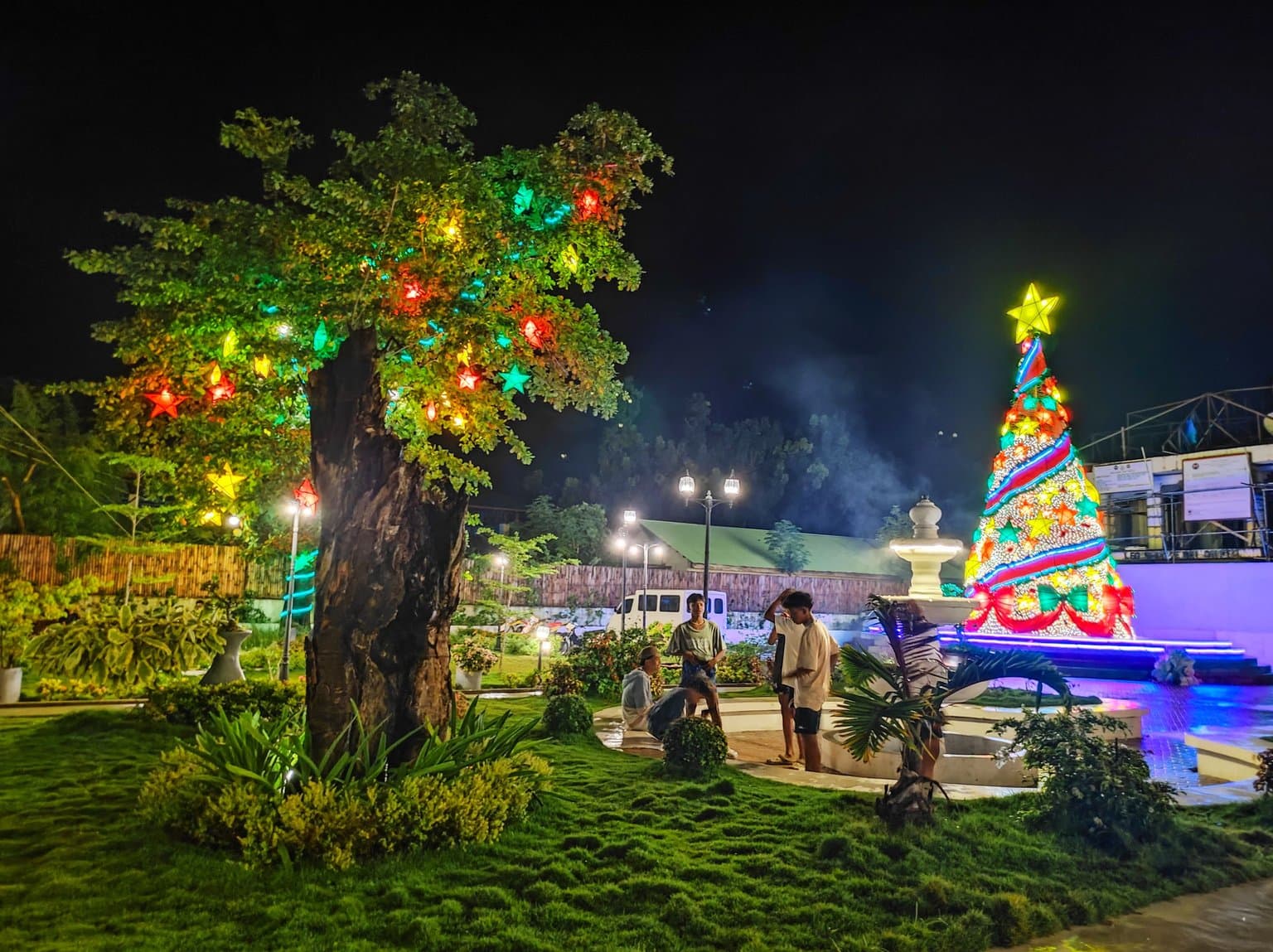 Kids standing around a Christmas tree on display at General Luna Municipal Hall