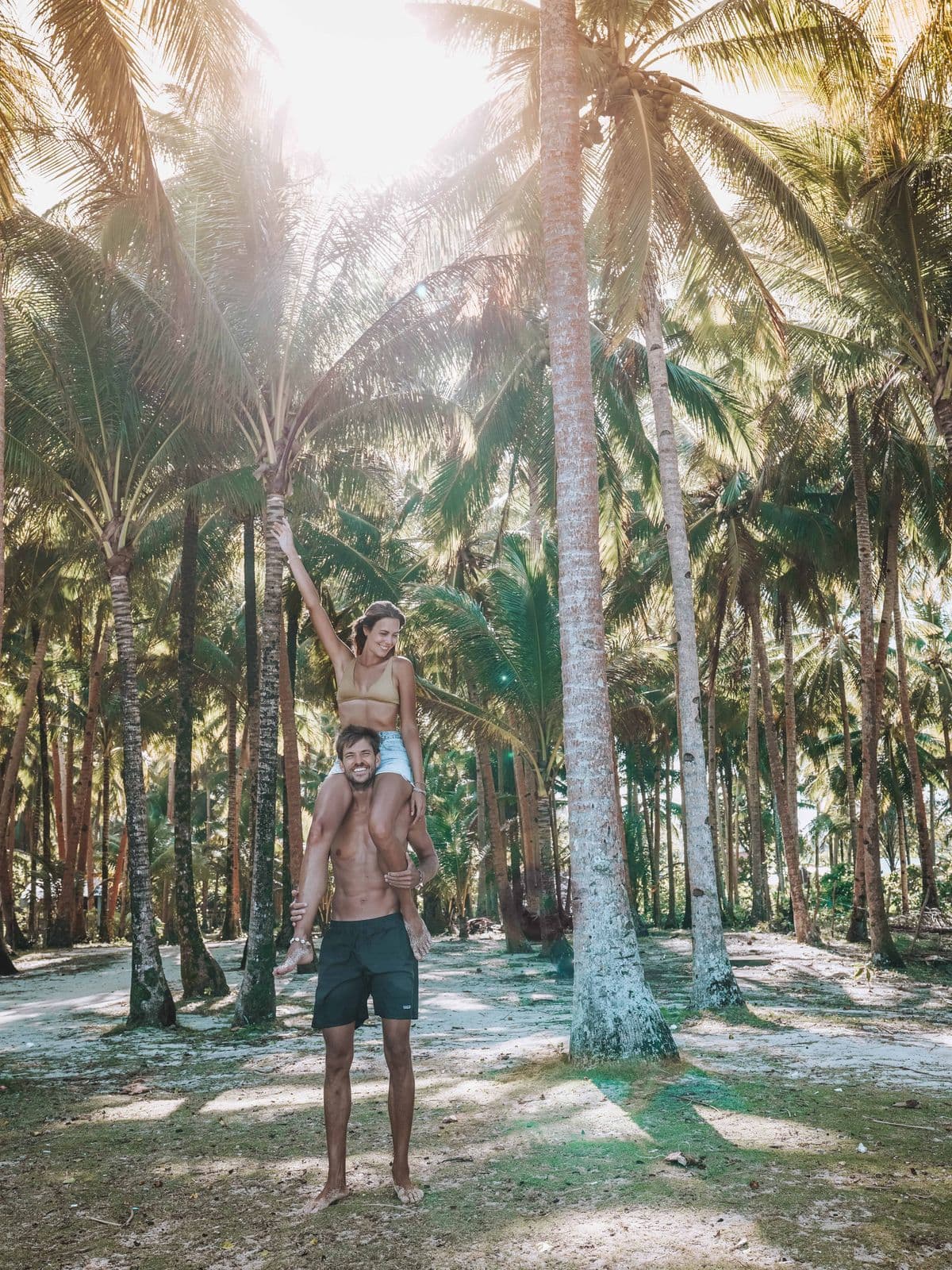 Couple under the palm trees at Alegria Beach, Siargao