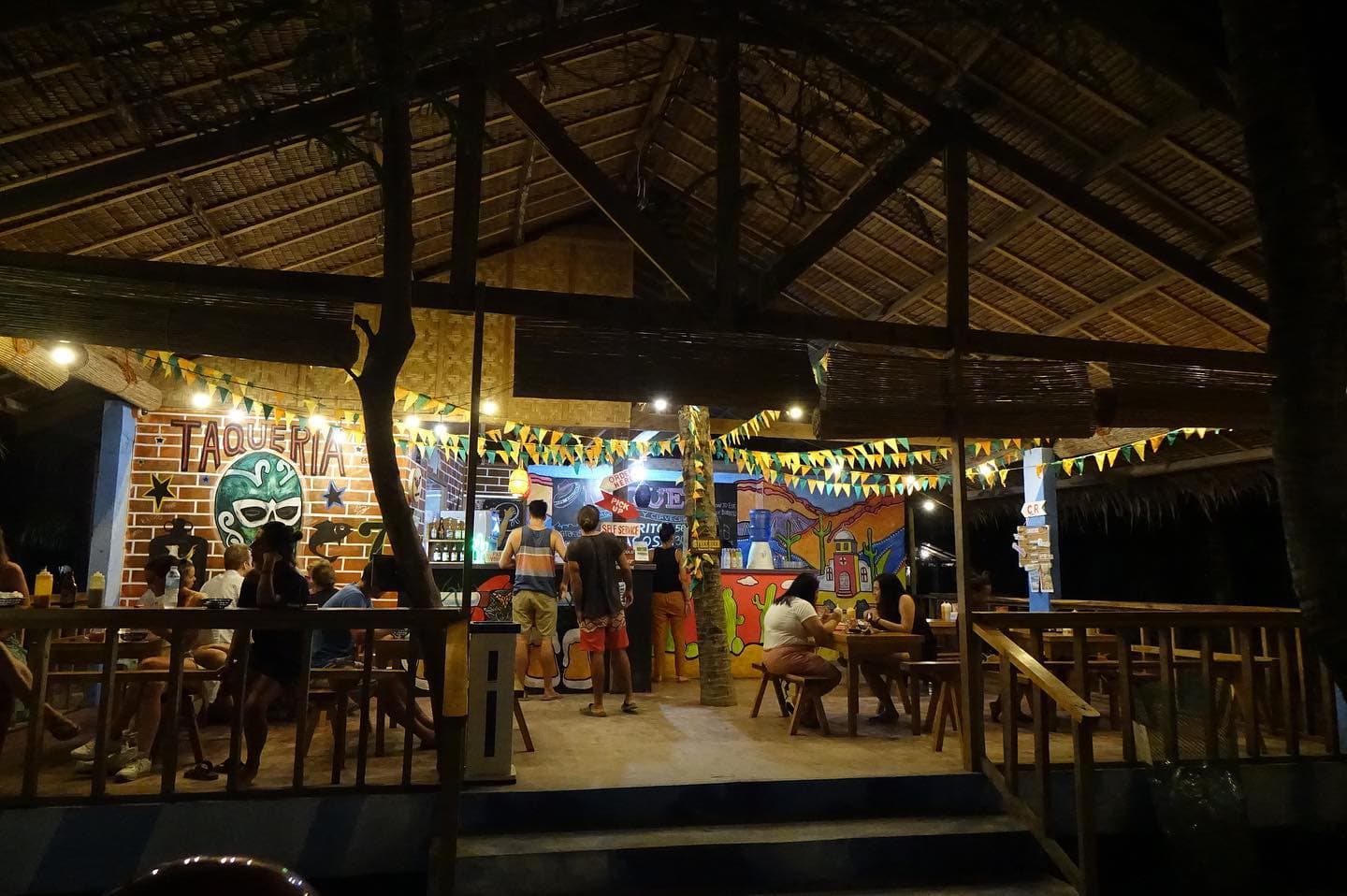 Open air restaurant with wooden tables at night