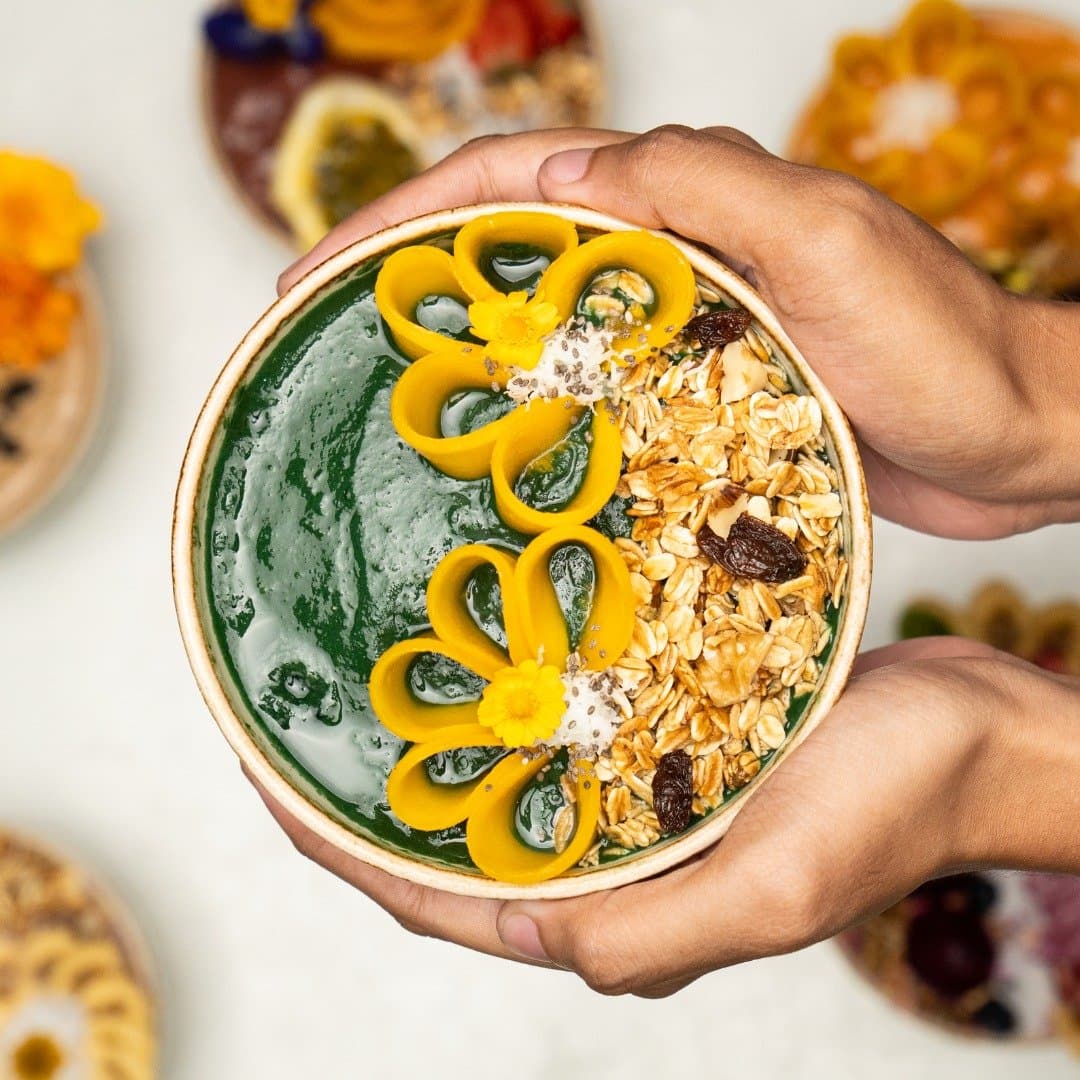 Green smoothie bowl topped with mango and granola