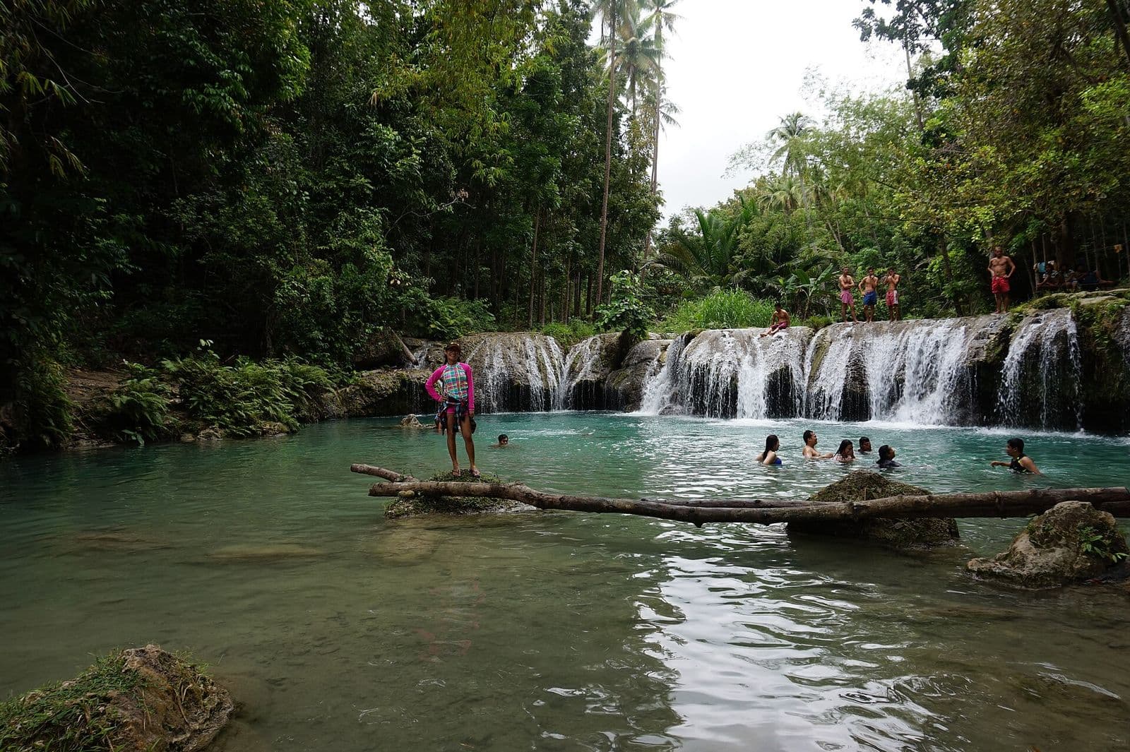 Swimmers in the pool below the cascades at Cambugahay Falls