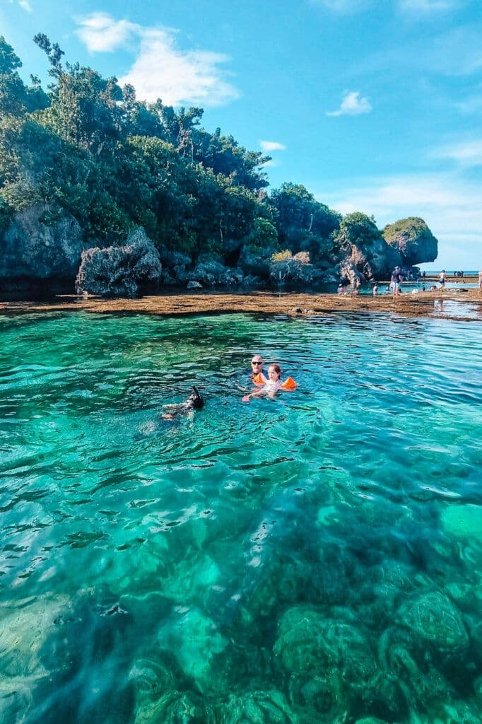 Kids in life vests swimming at Tayangban Cave Pool, Siargao