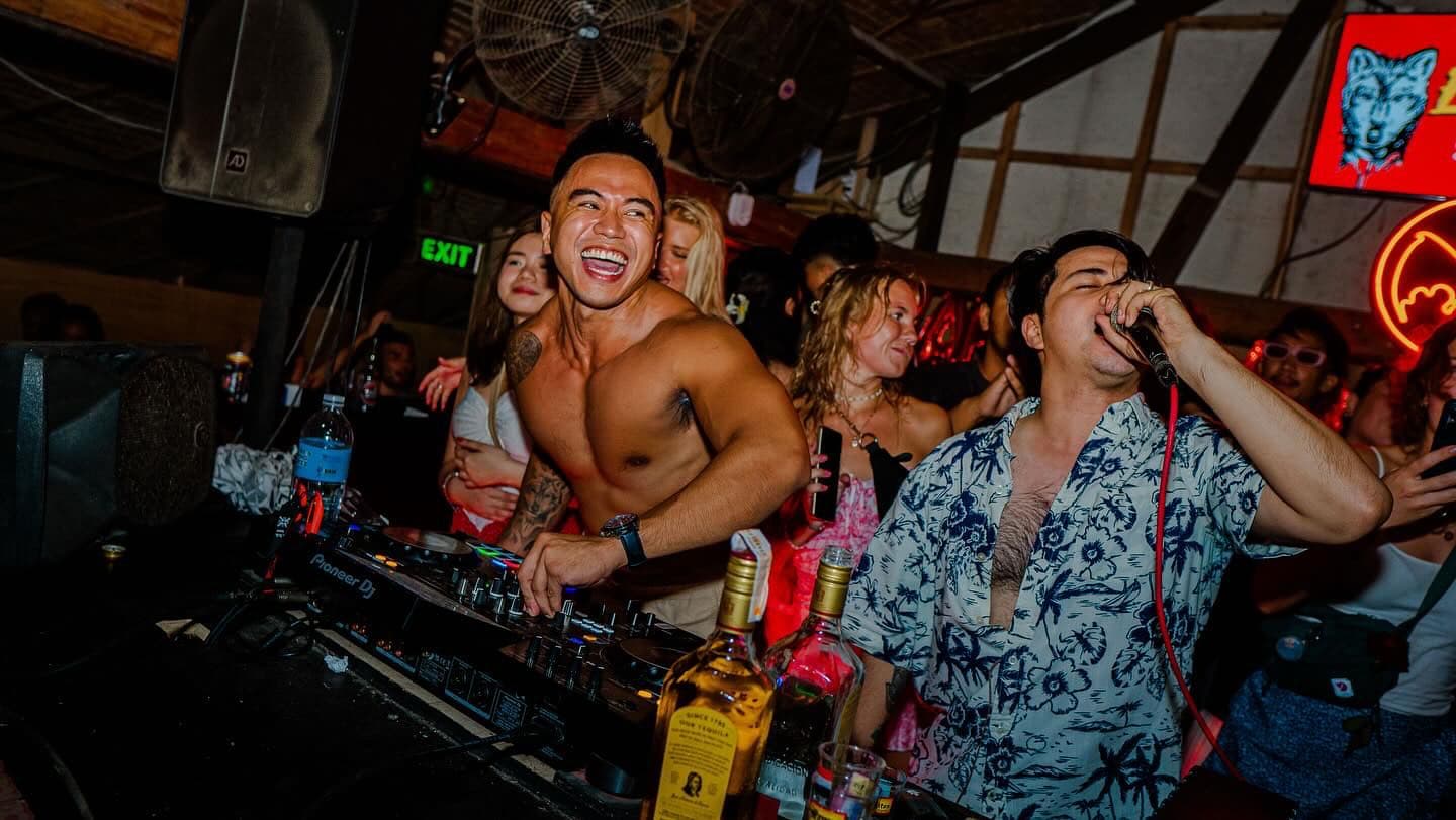 Crowd drinking and laughing at a busy bar