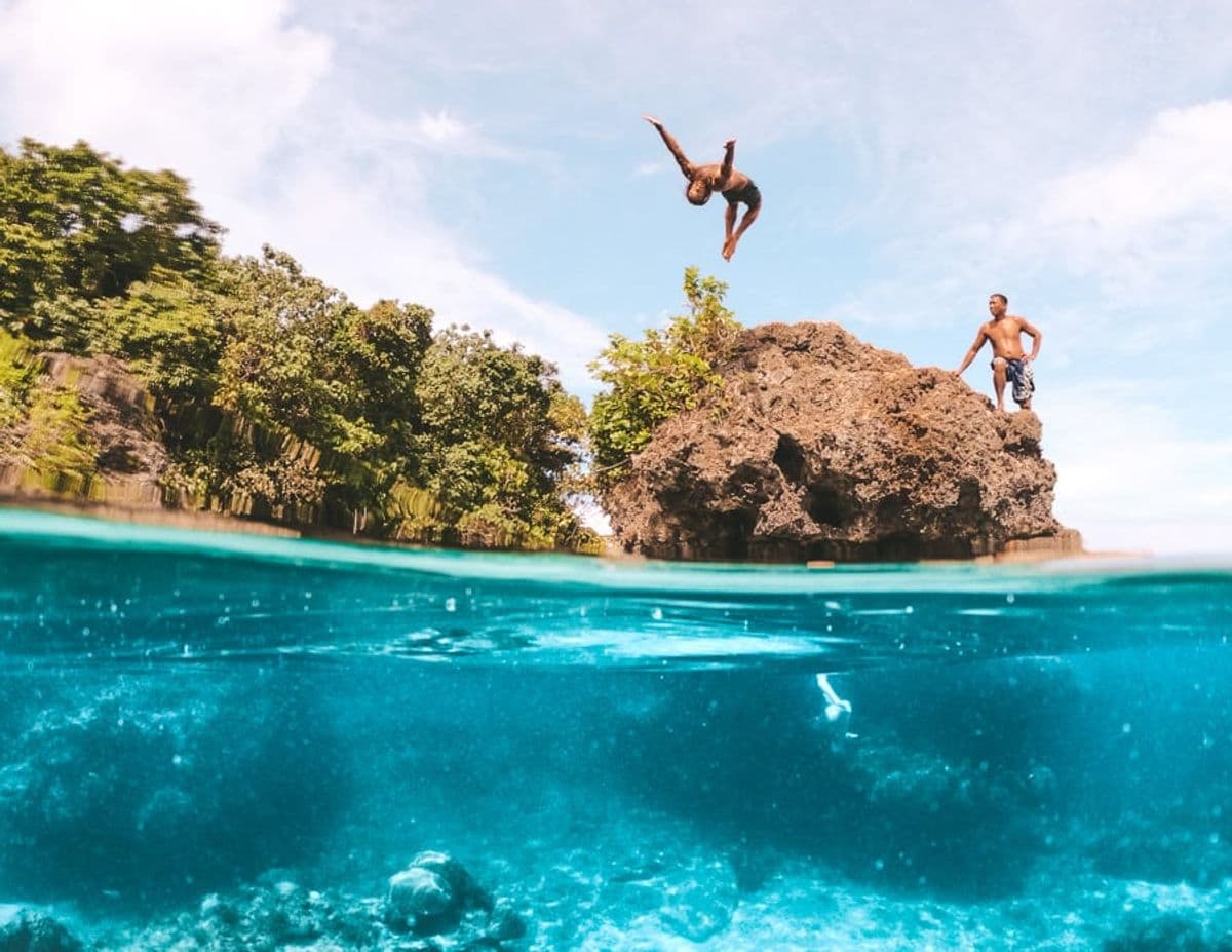 Two people jumping from the rocks into a pool at Magpupungko Rock Pools, Pilar, Siargao